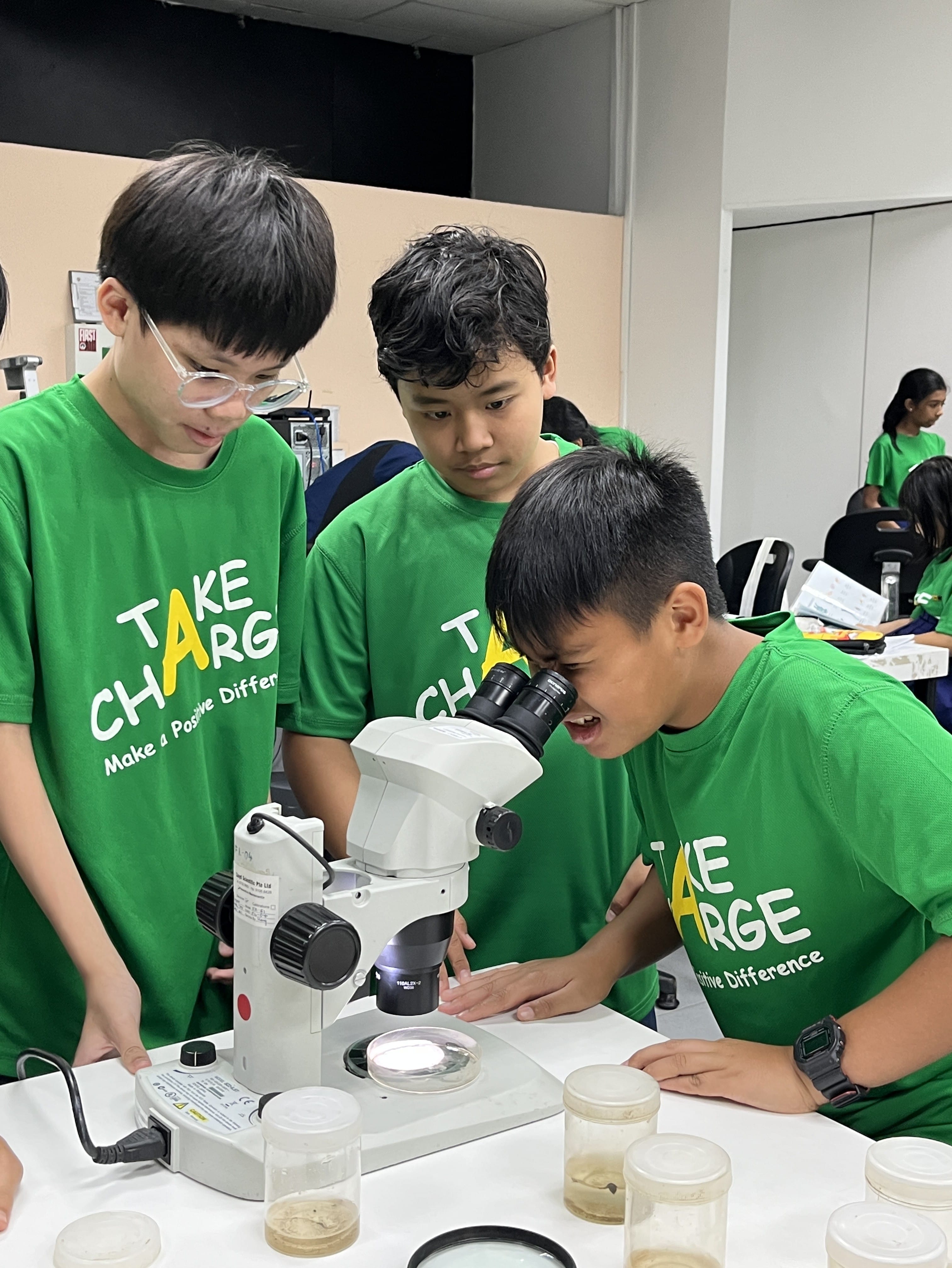 A student examining the specimen more closely through a microscope